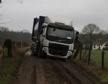 Vuilniswagen raakt paal en blijft vastzitten