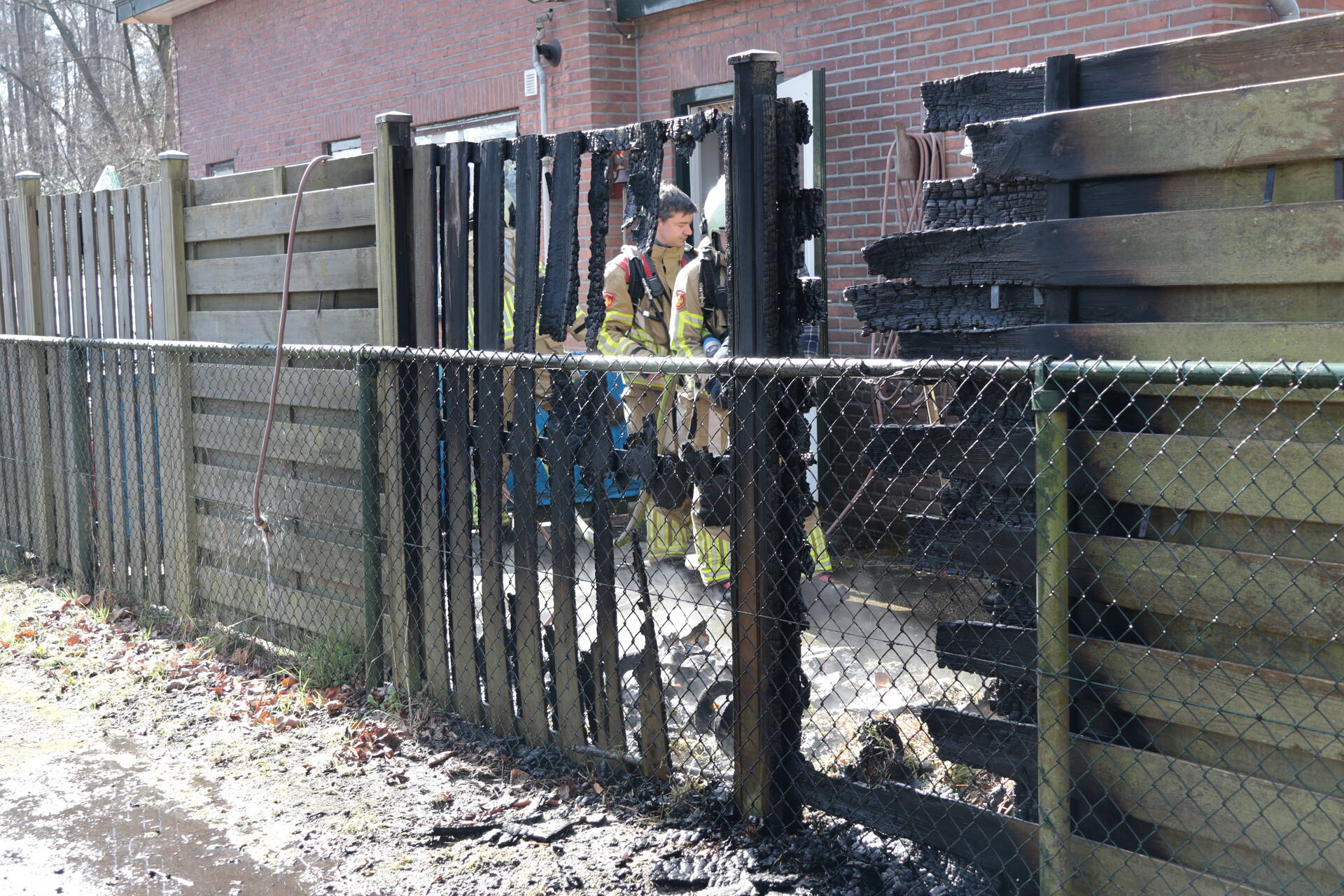 Brand in afvalbakken slaat over naar schutting