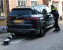 Auto botst tegen woning na aanrijding met paal