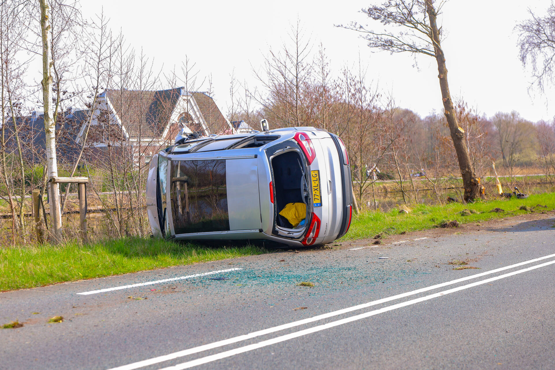 Auto belandt op zijn kant na botsing met boom