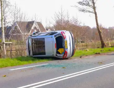 Auto belandt op zijn kant na botsing met boom