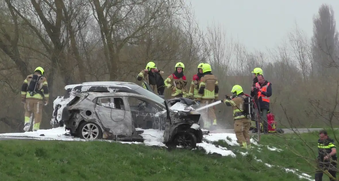 Vlammen uit auto na aanrijding - Foto 1