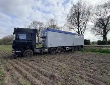 Vrachtwagen ramt auto en belandt in weiland