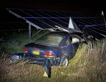 Auto boort zich in zonnepanelen na botsing met taxi