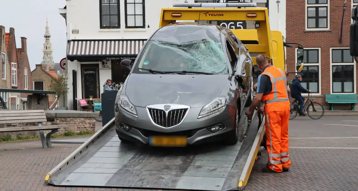 Auto op de kop op steiger na vergeten handrem
