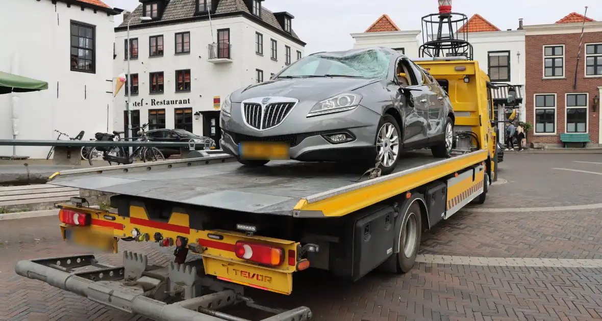 Auto op de kop op steiger na vergeten handrem - Foto 1