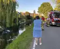 Auto belandt op de kop in het water, omstanders verrichten redding