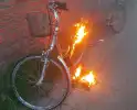 Fiets in brand tegen gevel van woning