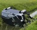 Auto belandt op zijkant in sloot naast snelweg