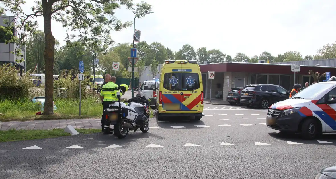 Omstanders halen inzittenden uit te water geraakt voertuig