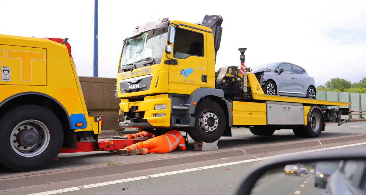 Wegdek vol olie na aanrijding tussen camper en bergingsvoertuig