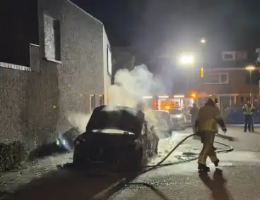 Auto in brand bij woning