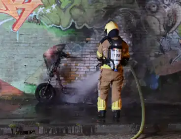 Scooter in brand naast opslag bij Kwik Fit