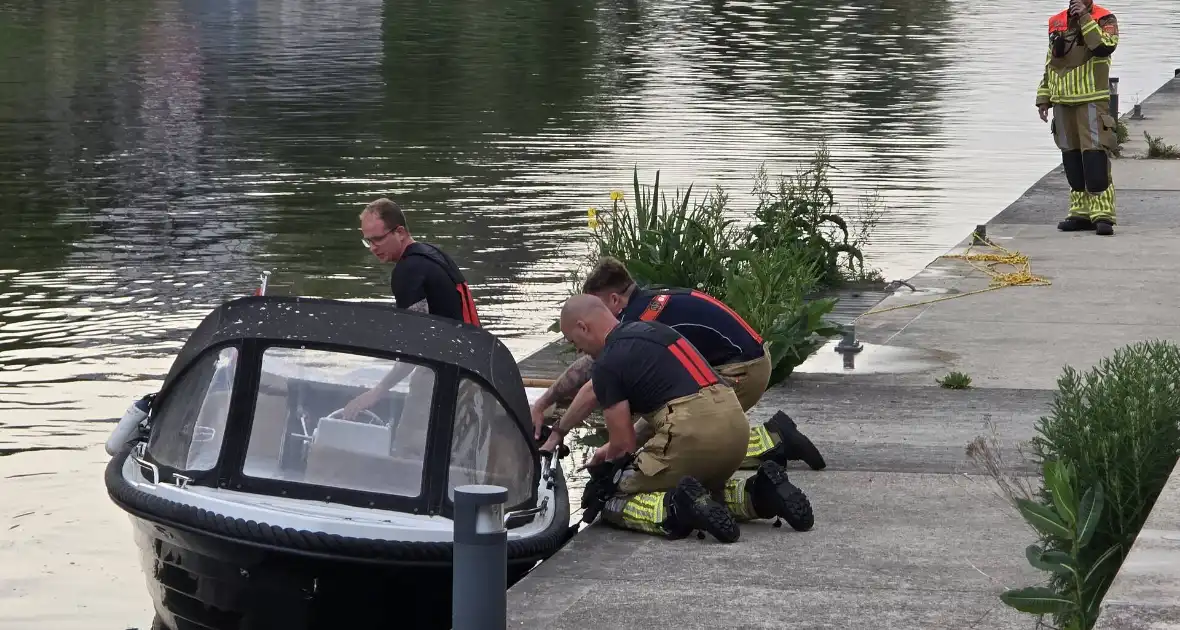 Brandweer haalt boot naar kade na brand