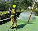 Brandend kunstgras geblust door brandweer