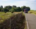 Brandweer blust brand in berm van dijk