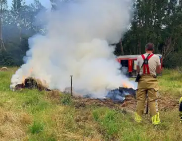 Brandweer blust brand in hooibaal