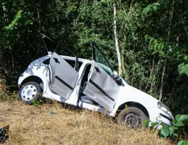 Auto botst door berm en hekwerk