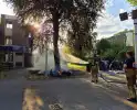 Brandweer blust brandend object tegen boom