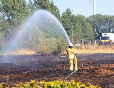 Groot stuk gras in brand naast transportbedrijf