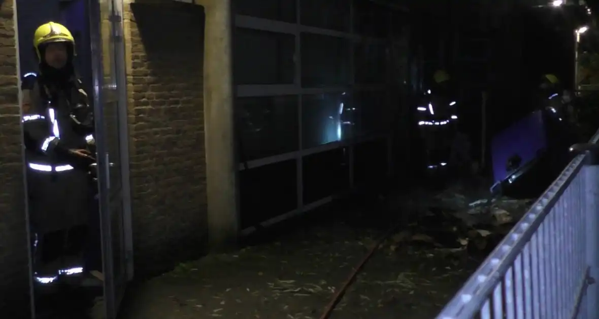 Brandweer blust brandende container tegen school - Foto 1