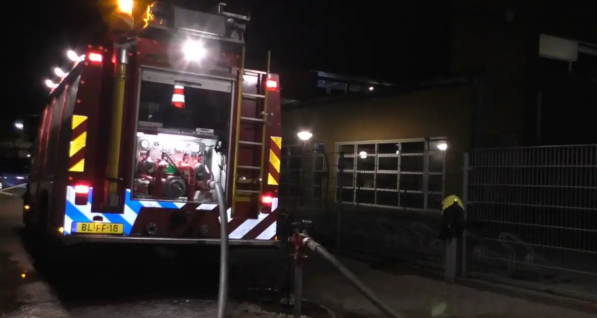 Brandweer blust brandende container tegen school - Foto 2