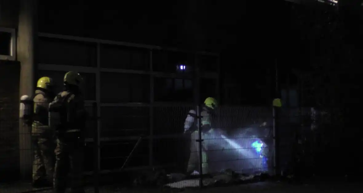 Brandweer blust brandende container tegen school - Foto 3