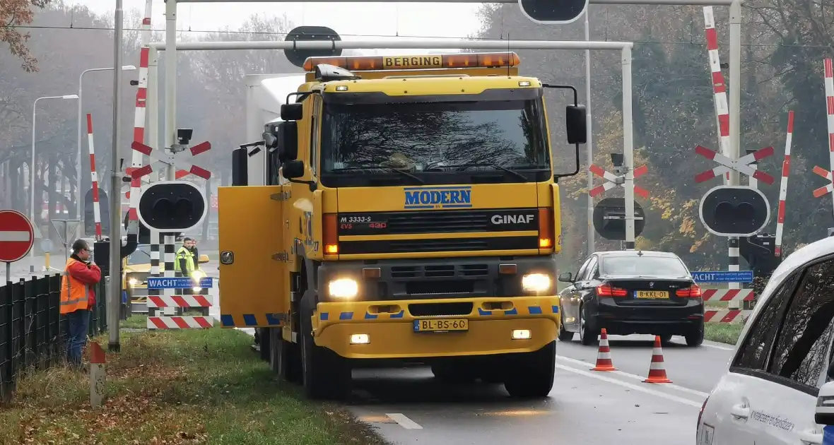 Vrachtwagen blokkeert weg bij spoorwegovergang - Foto 1