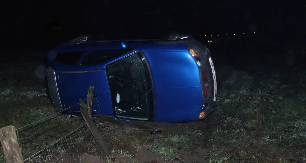 Auto op z'n zijkant naast de weg