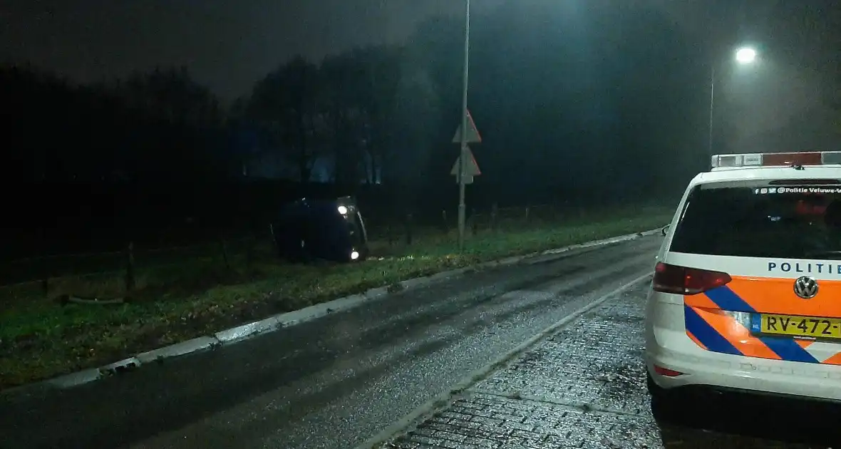 Auto op z'n zijkant naast de weg - Foto 1