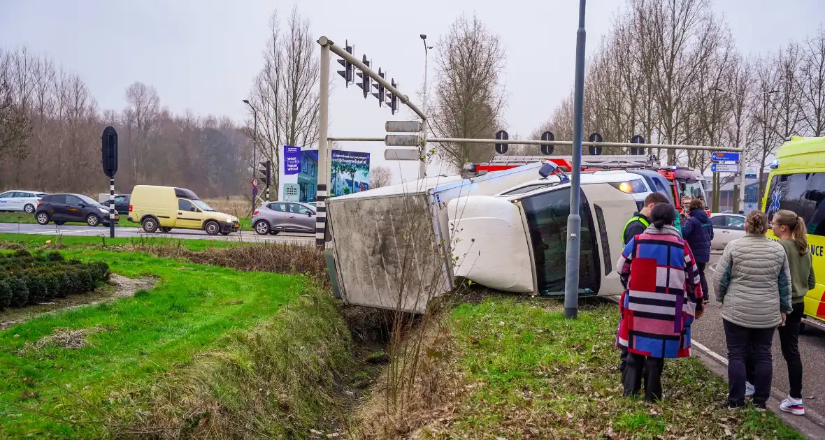 Bestelbus kantelt en belandt in sloot