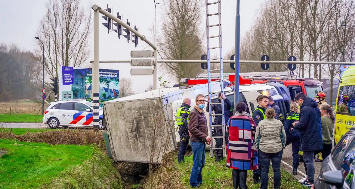 Bestelbus kantelt en belandt in sloot - Foto 1