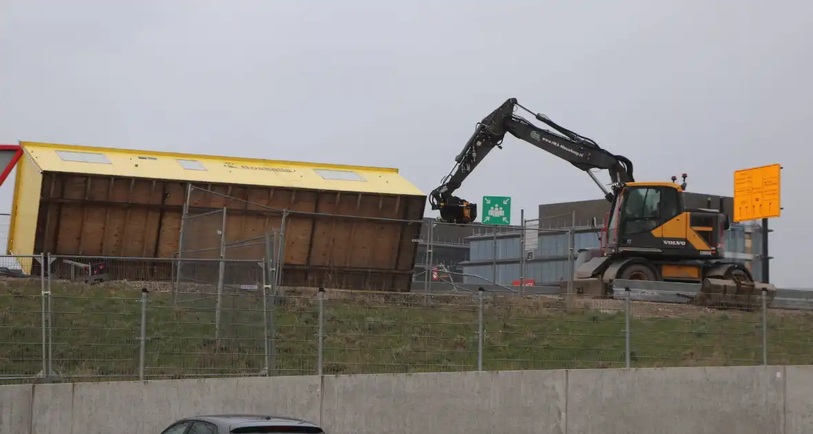 Bouwkeet waait om en belandt op wegdek - Foto 4