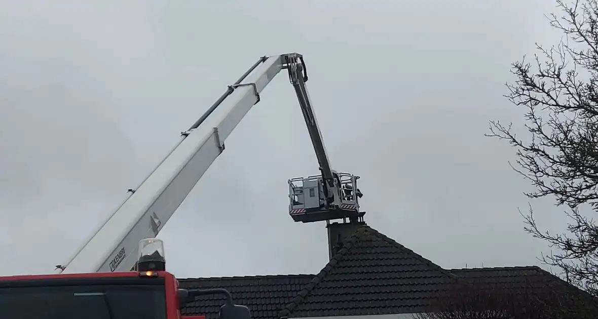 Brandweer verwijderd losse plaat op schoorsteen van woning - Foto 2