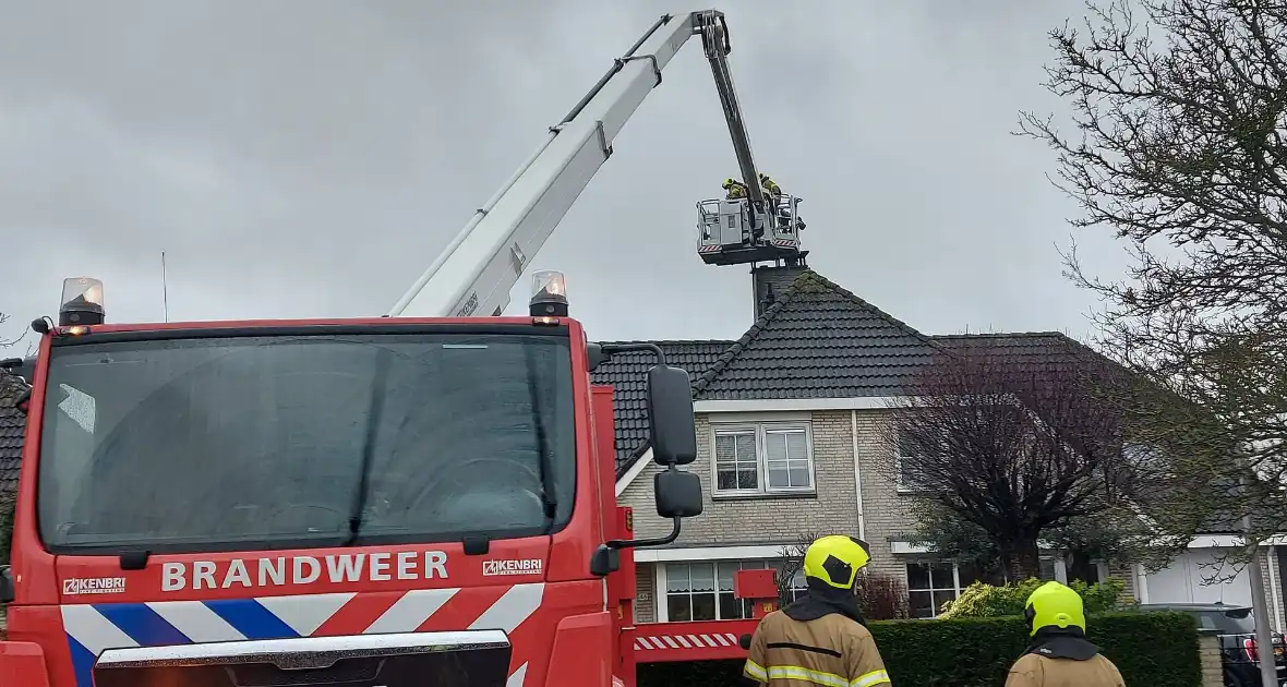 Brandweer verwijderd losse plaat op schoorsteen van woning - Foto 3