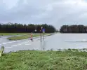 Wegdek en fietspad onder water door hevige regenval
