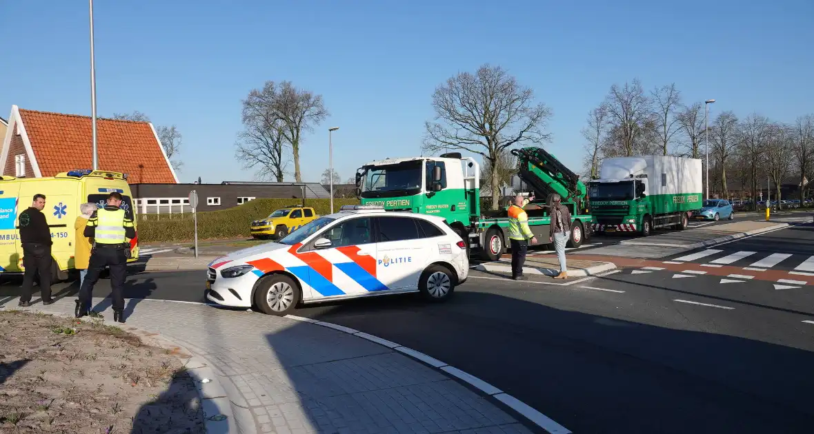 Auto schept e-biker op rotonde