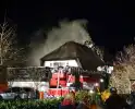 Brand in dak van villa met rietendak
