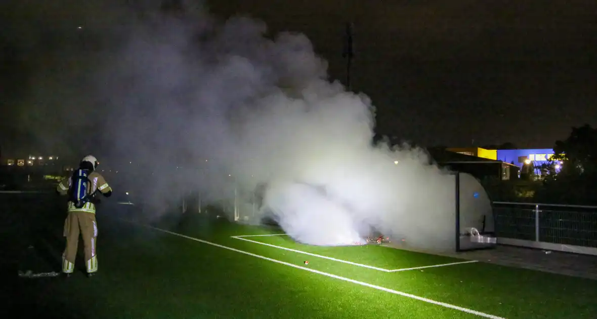Vlammen op voetbalveld vanwege brand in afvalcontainer - Foto 2