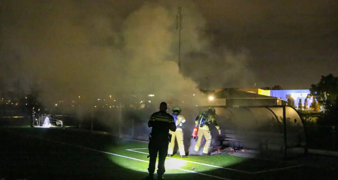 Vlammen op voetbalveld vanwege brand in afvalcontainer - Foto 4