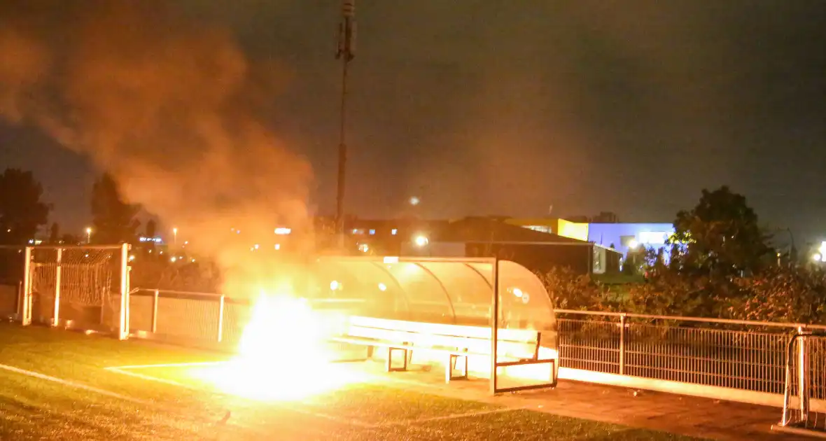 Vlammen op voetbalveld vanwege brand in afvalcontainer - Foto 6