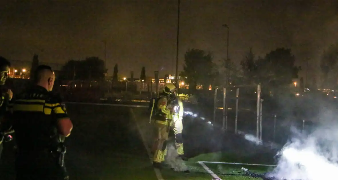 Vlammen op voetbalveld vanwege brand in afvalcontainer - Foto 7