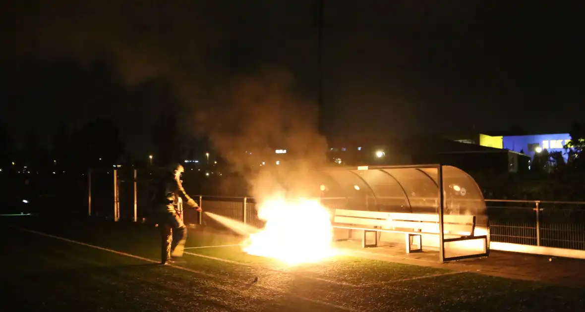 Vlammen op voetbalveld vanwege brand in afvalcontainer - Foto 9