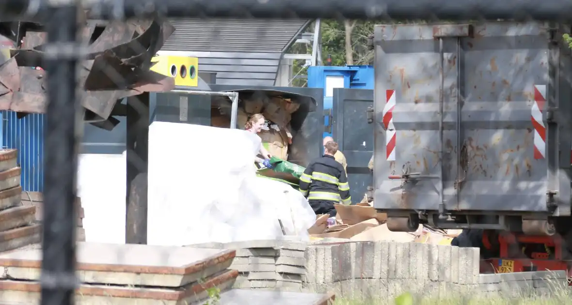 Man bekneld in papiercontainer op afvalbrengstation - Foto 1