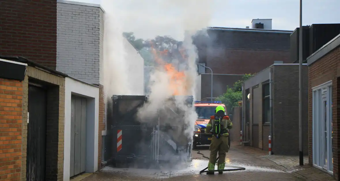 Vlammen slaan uit bouwcontainer met afval - Foto 3