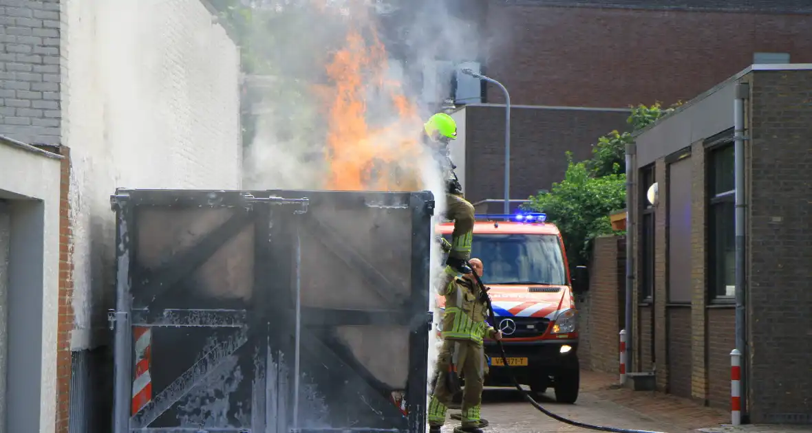 Vlammen slaan uit bouwcontainer met afval - Foto 8