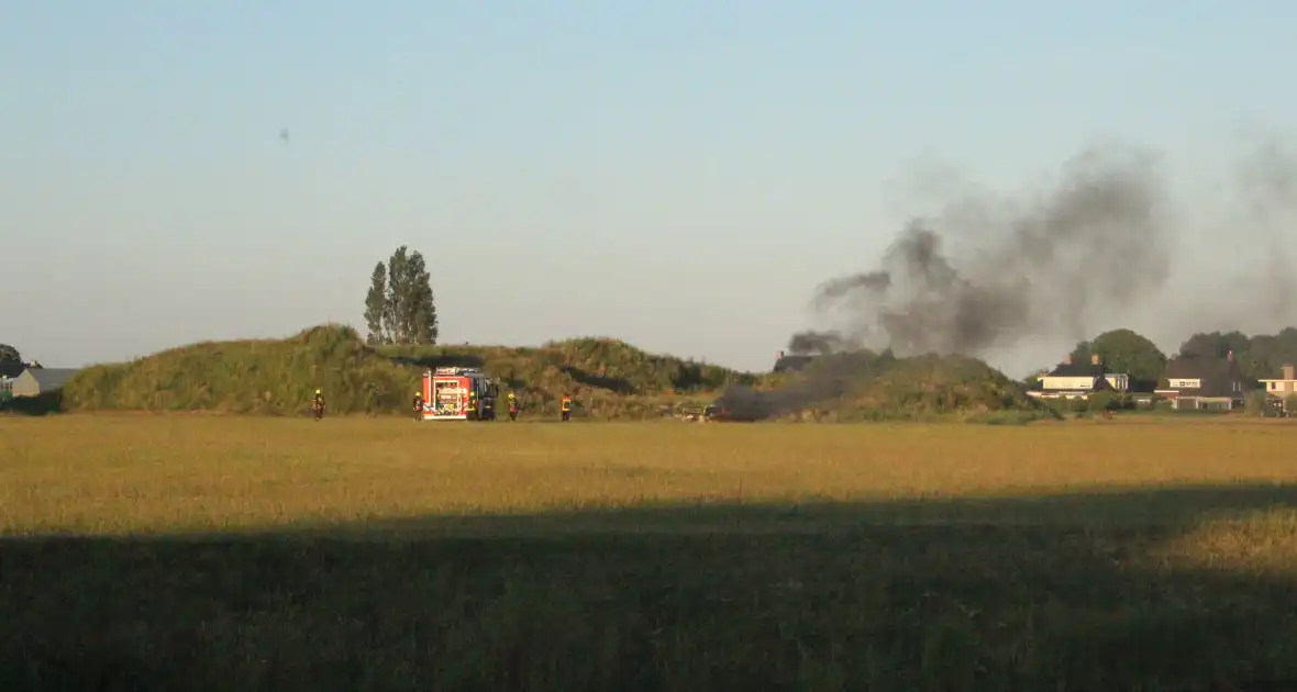 Auto midden in het veld verwoest vanwege brand - Foto 1
