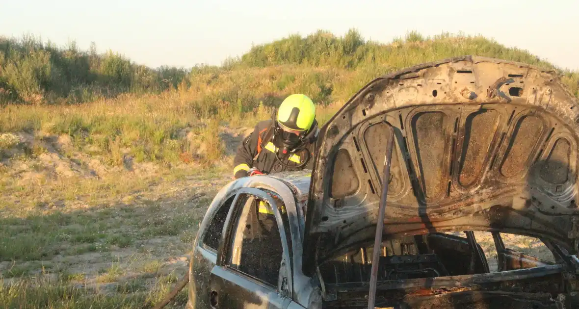 Auto midden in het veld verwoest vanwege brand - Foto 10