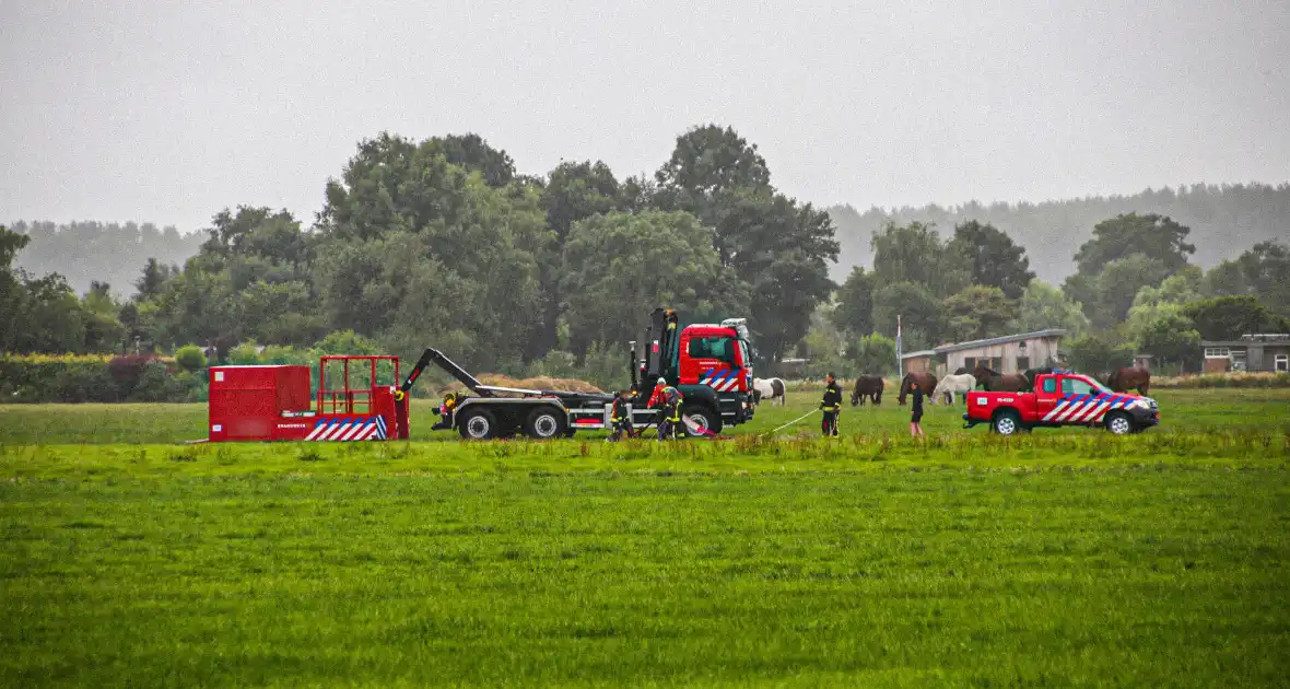 Paard met kraan uit sloot getakeld